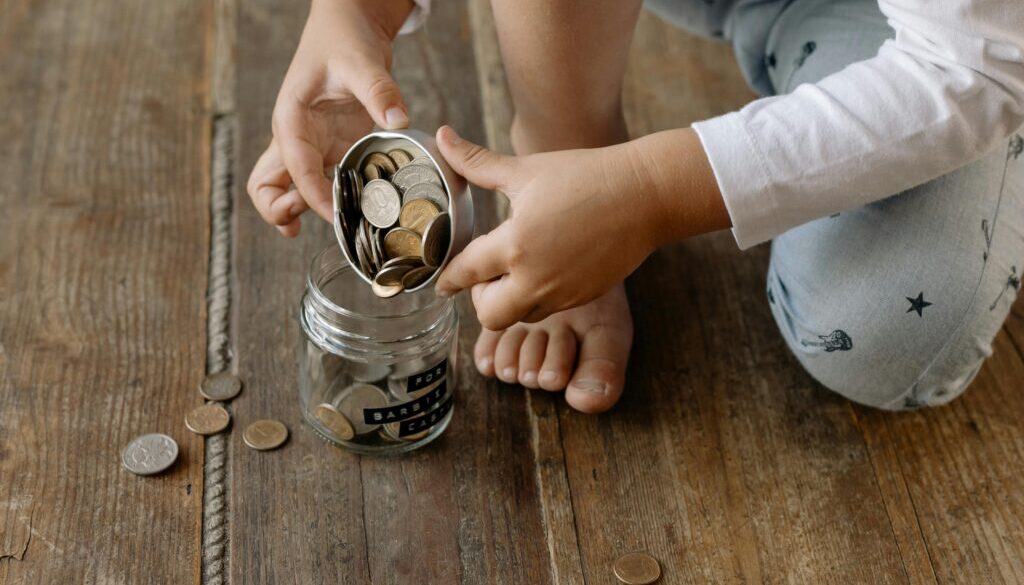 A person putting the coins inside the glass jar